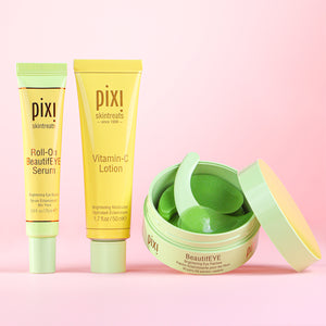 Pixi skincare products including Roll-on BeautifEYE serum, Vitamin-C lotion, and BeautifEYE brightening eye patches on a pink background